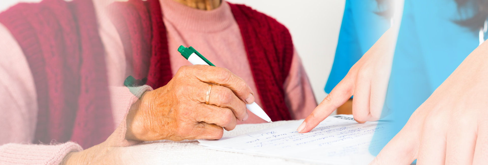 caregiver assisting elderly on writing